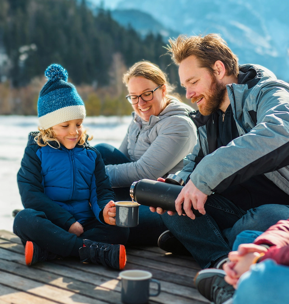 Eine Familie macht Pause neben einem Fluss